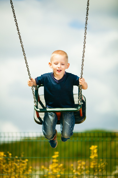 Little blonde  child having fun on a swing outdoor - Photo, image