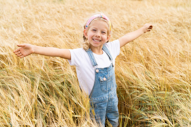 Piccola ragazza bionda nel campo della segale, raccolto di grano - Foto, immagini