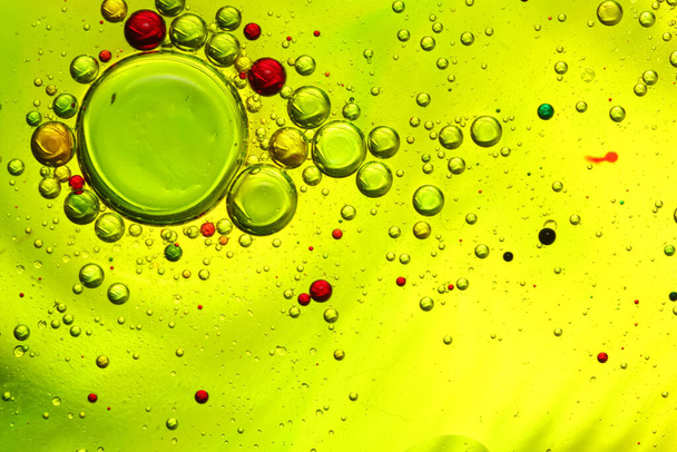 öljykuplia vedellä lasilla ja värillinen tausta - Valokuva, kuva