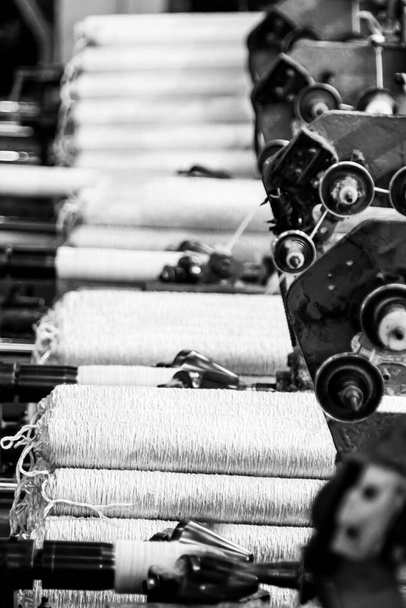 JOHANNESBURG, SOUTH AFRICA - Jan 06, 2021: A grayscale of a cotton thread Bobin on a cop winder weft assembly line loom in South Africa - Fotoğraf, Görsel