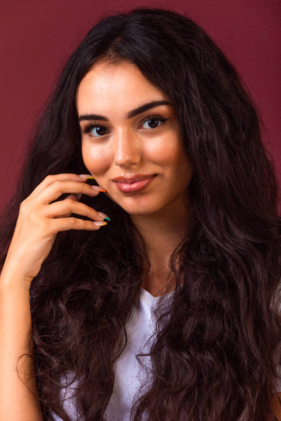 Mladá brunetka dívka s dlouhými a kudrnatými vlasy propagující podzimní make-up styl. Kvalitní fotografie - Fotografie, Obrázek