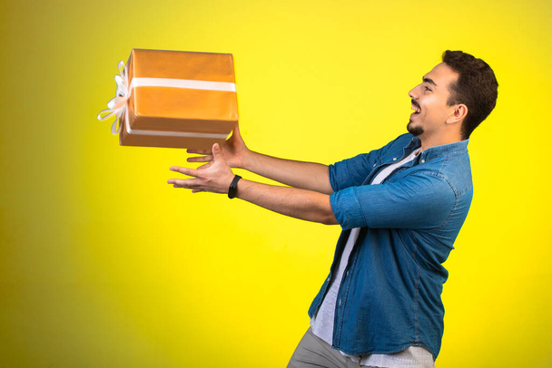 Un homme tenant une boîte-cadeau volante. Photo de haute qualité - Photo, image