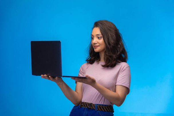  Female employee with a black laptop having video call and smiling. High quality photo - Фото, зображення