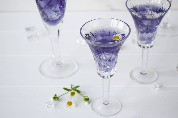 vasos de cristal con licor de lavanda sobre la mesa - Foto, Imagen