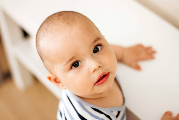 Cutte little baby with big dark eyes and long lashes. Sweet infant at home - Φωτογραφία, εικόνα
