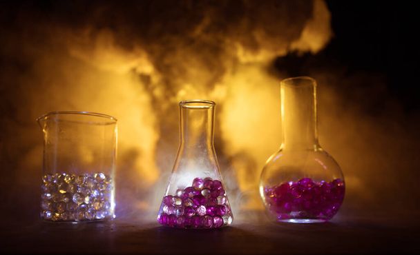 Pharmacy and chemistry theme. Test glass flask with solution in research laboratory. Science and medical background. Laboratory test tubes on abstract explosion cloud background. Selective focus - Photo, Image