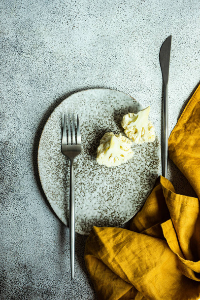 ボウルにカリフラワーのスライスと健康的な生の食品の概念 - 写真・画像