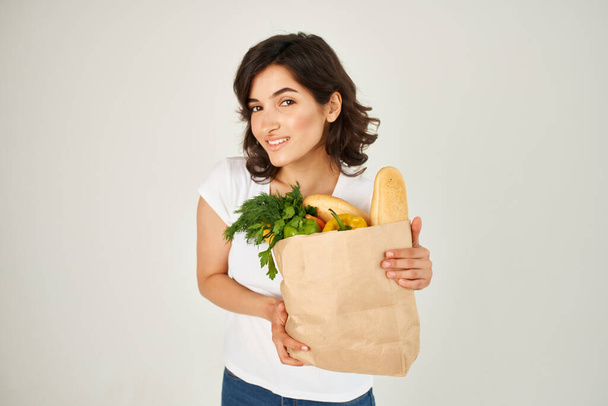 vrouw in wit t-shirt pakket met gezonde voeding groenten - Foto, afbeelding