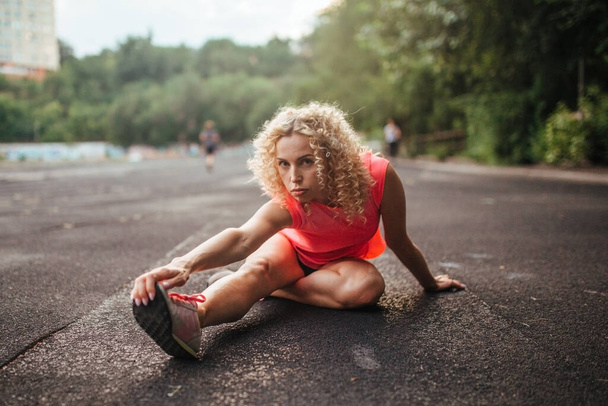 κορίτσι αθλητής κάνει τέντωμα πριν από την εκπαίδευση - Φωτογραφία, εικόνα