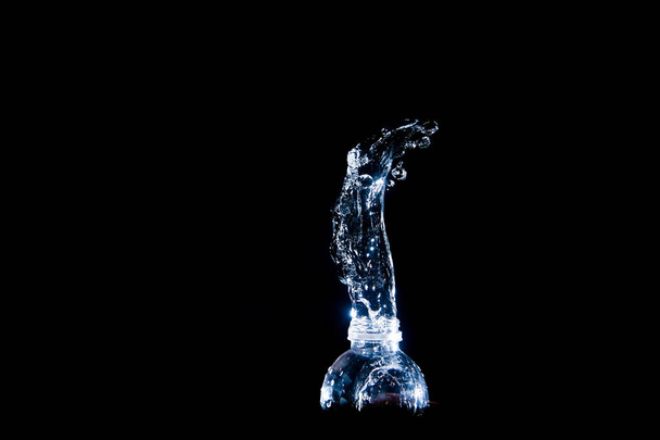 Scattered water splashes on a black background. Drinking water is refreshing. - Foto, immagini