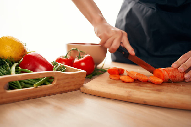τεμαχίζοντας καρότα στην κουζίνα μαγείρεμα σαλάτα βιταμίνες για την υγεία - Φωτογραφία, εικόνα