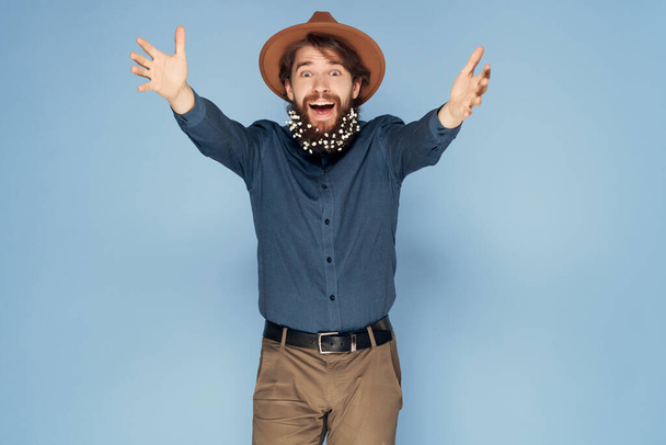 schöner Mann mit Hut trägt Hemdblumen im Bart isoliert Hintergrund - Foto, Bild