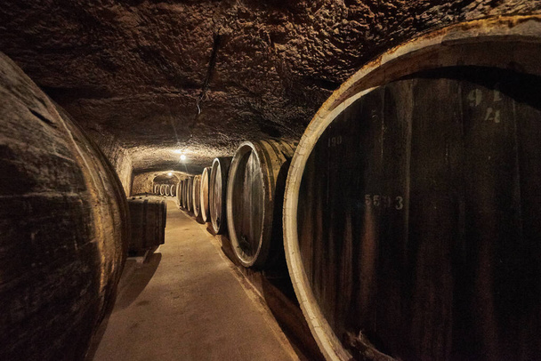 Старий льох з великими дерев'яними бочками алкогольного вина
 - Фото, зображення