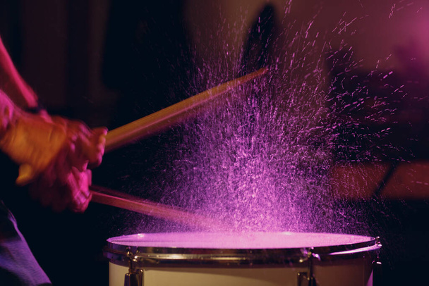 Drumstokken drumritme ritme op het trommeloppervlak met spatwaterdruppels - Foto, afbeelding