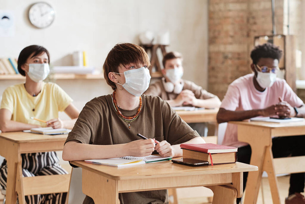 Estudiantes con máscaras estudiando en la escuela - Foto, imagen