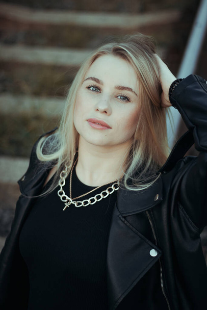 portrait of a young beautiful blonde with blue eyes woman close-up. in black clothes - Foto, Bild