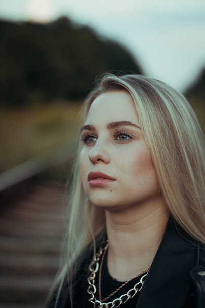 portrait of a young beautiful blonde with blue eyes woman close-up. in black clothes - Foto, Imagem