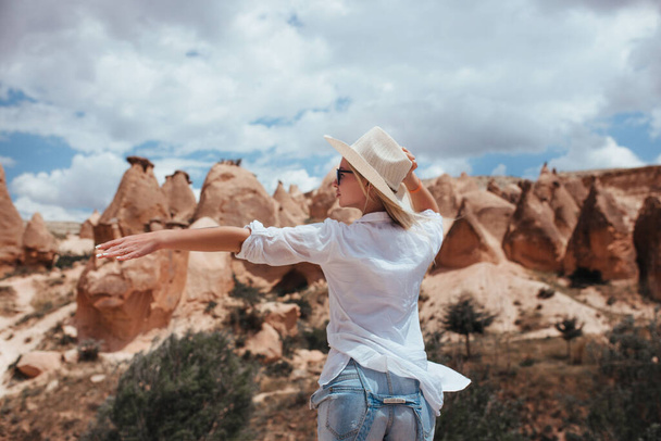 a beautiful girl in a white shirt and hat catches a ride to hitchhike in Cappadocia - Photo, image