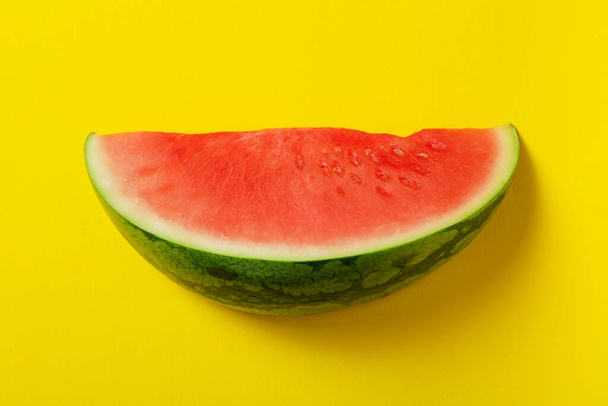 Ripe juicy watermelon slice on yellow background - Фото, изображение