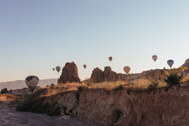 hete lucht ballon parade in cappadocië bij zonsopgang - Foto, afbeelding
