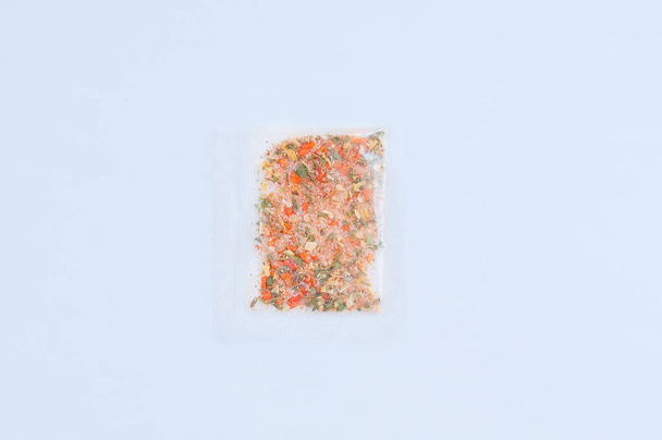 Seasoning for food in a transparent bag close-up on a white background. - Foto, Imagem