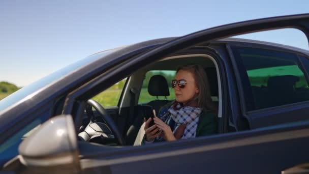 車に座って携帯電話を使う女性. - 映像、動画