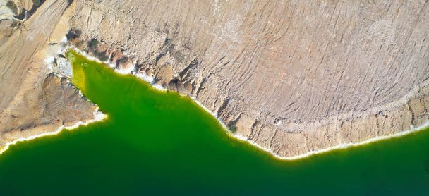 Shore of toxic green lake in abandoned open pit copper mine. its color derives from high levels of acid and heavy metals. Aerial panorama from directly above - Photo, Image