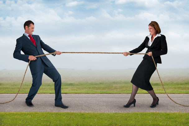 zakenman en vrouw touwtrekken - Foto, afbeelding