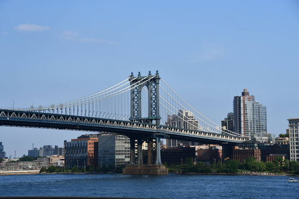 НЬЮ-ЙОРК, Нью-Йорк - 20 июня: Манхэттенский мост в Нью-Йорке, замеченный 20 июня 2021 года, представляет собой подвесной мост, пересекающий Ист-Ривер в Нью-Йорке, соединяющий Нижний Манхэттен с центром Бруклина. - Фото, изображение