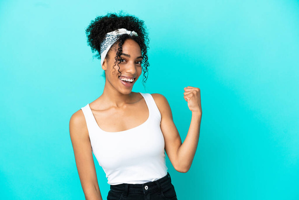Young latin woman isolated on blue background celebrating a victory - Photo, Image