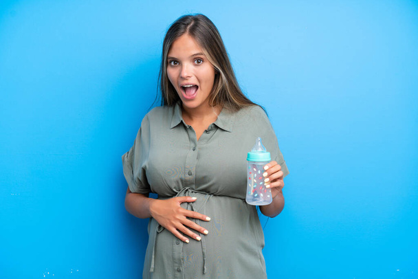 Mulher grávida em fundo azul com expressão facial surpresa - Foto, Imagem