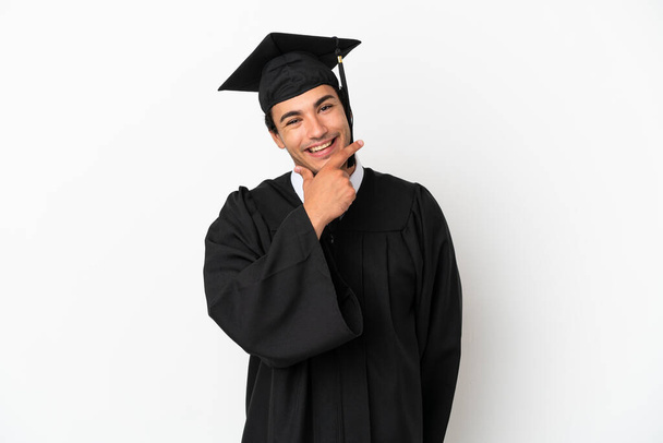 Mladá univerzita absolvent přes izolované bílé pozadí s úsměvem - Fotografie, Obrázek
