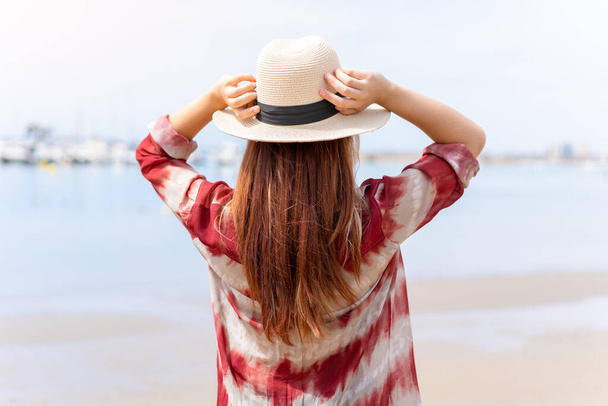 Молодая симпатичная блондинка на пляже во время летних каникул в позе спины - Фото, изображение