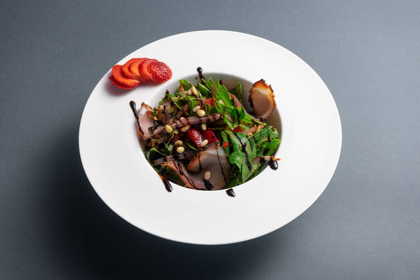 closeup of fresh salad with arugula, meat ham and strawberry on black background - Fotografie, Obrázek