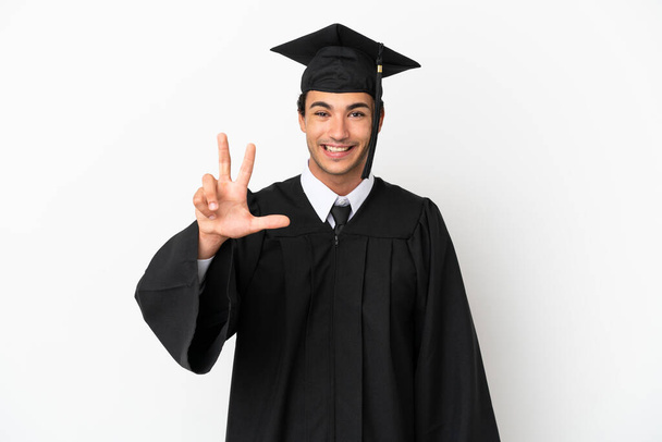 Joven graduado universitario sobre fondo blanco aislado feliz y contar tres con los dedos - Foto, imagen