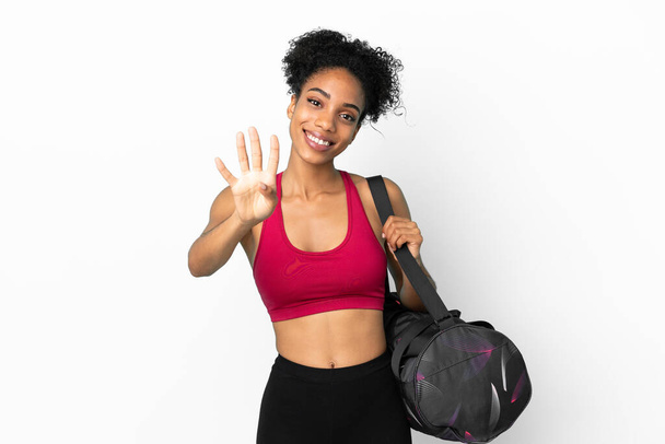 Junge Sport afrikanisch-amerikanische Frau mit Sporttasche isoliert auf blauem Hintergrund glücklich und zählen vier mit den Fingern - Foto, Bild