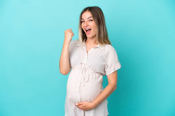 Νεαρή Ρουμάνα που απομονώθηκε σε μπλε φόντο έγκυος και πανηγύρισε νίκη - Φωτογραφία, εικόνα