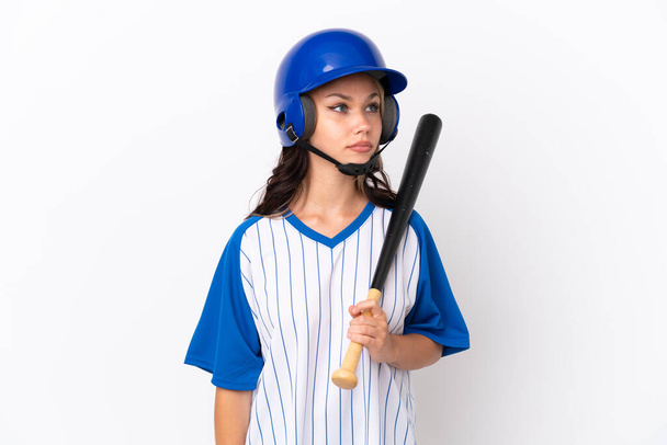 Baseball Russian girl player with helmet and bat isolated on white background looking to the side - Foto, Bild