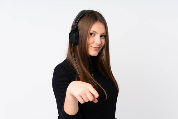 Teenager caucasian girl isolated on white background listening music - Φωτογραφία, εικόνα