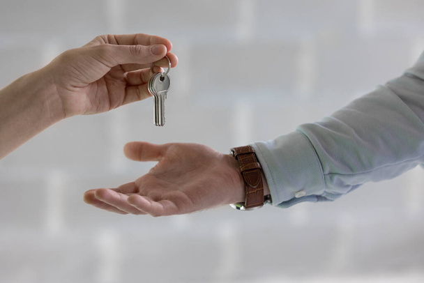 the keys to a new apartment or house, a woman or a man holds a bunch of keys or one key in his hand - Фото, изображение