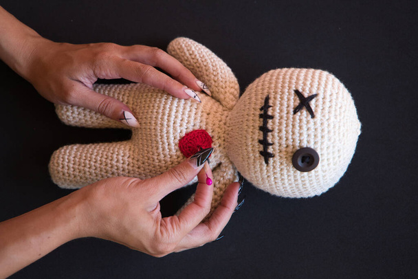 details van een heks die voodoo doet op een pop. Je kunt zien hoe ze naalden in de pop steekt. Hekserij - Foto, afbeelding