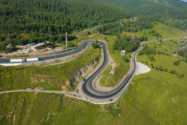 De Baikal serpentine weg - vanuit de lucht uitzicht op de natuurlijke bergvallei met serpantine weg, Trans-Siberische snelweg, Rusland, Kultuk, Slyudyanka - Foto, afbeelding