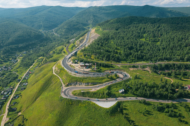 De Baikal serpentine weg - vanuit de lucht uitzicht op de natuurlijke bergvallei met serpantine weg, Trans-Siberische snelweg, Rusland, Kultuk, Slyudyanka - Foto, afbeelding