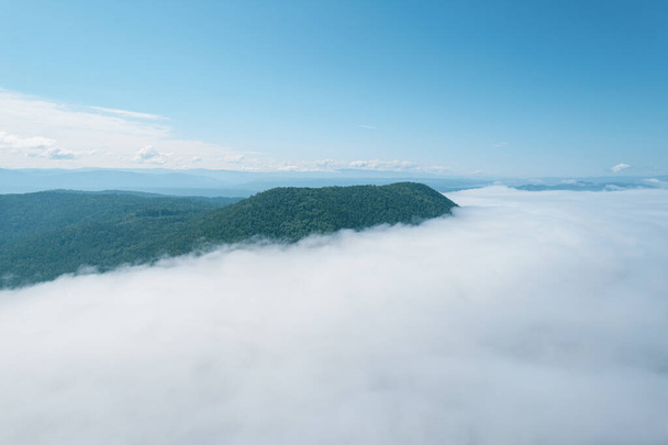 山頂上の雲の中を飛ぶ。高いピーク素晴らしい朝の日の出自然景観 - 写真・画像