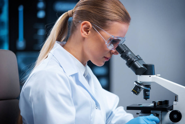 Female doctor works in a modern scientific laboratory using equipment and computer technologies. The scientist does research and develops new vaccines. Science and healthcare concept. - Foto, Imagem