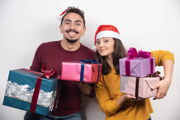Uomo e donna che portano un sacco di regali di Natale. Foto di alta qualità - Foto, immagini