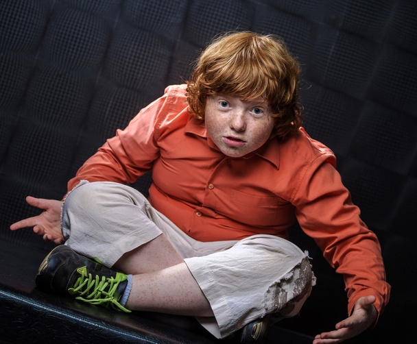 Freckled red-hair boy posing on dark background. - Photo, image
