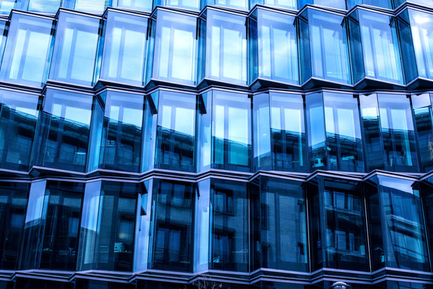 Moderna fachada de cristal de un edificio de oficinas, reflejo del cielo en las ventanas. - Foto, Imagen
