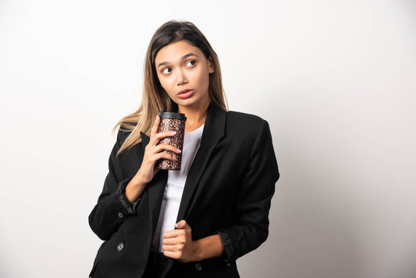 Business woman holding cup and posing on white background . High quality photo - Foto, immagini