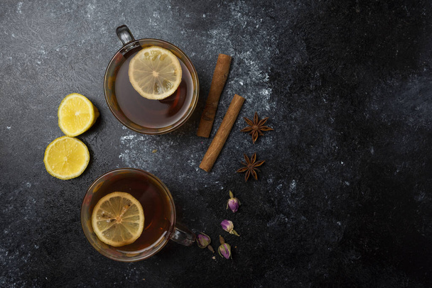 Herbal winter tea in the cups with spices on black background. High quality photo - Photo, Image